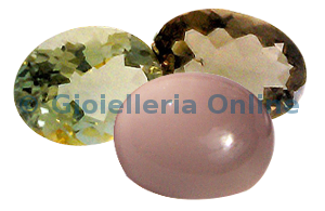 immagine di alcune gemme semipreziose ovali, due quarzi var prasio, un quarzo citrino e un quarzo 
affumicato.
